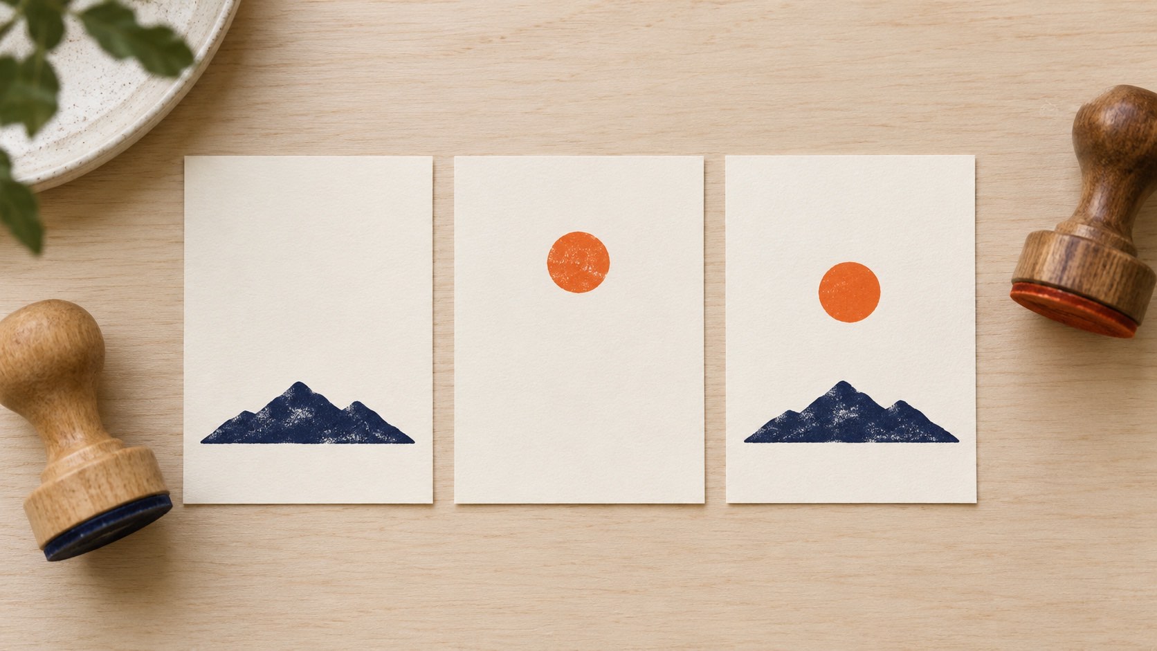 Three illustrative cards with a navy mountain, an orange sun and the combined motif